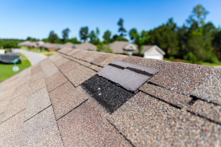 Wind storm damage to a shingle roof