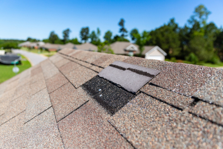 Wind storm damage to a shingle roof